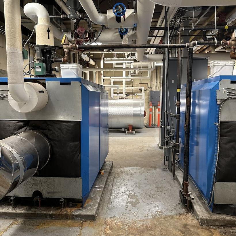 Twin boiler plant and insulated distribution piping in a multi-family building